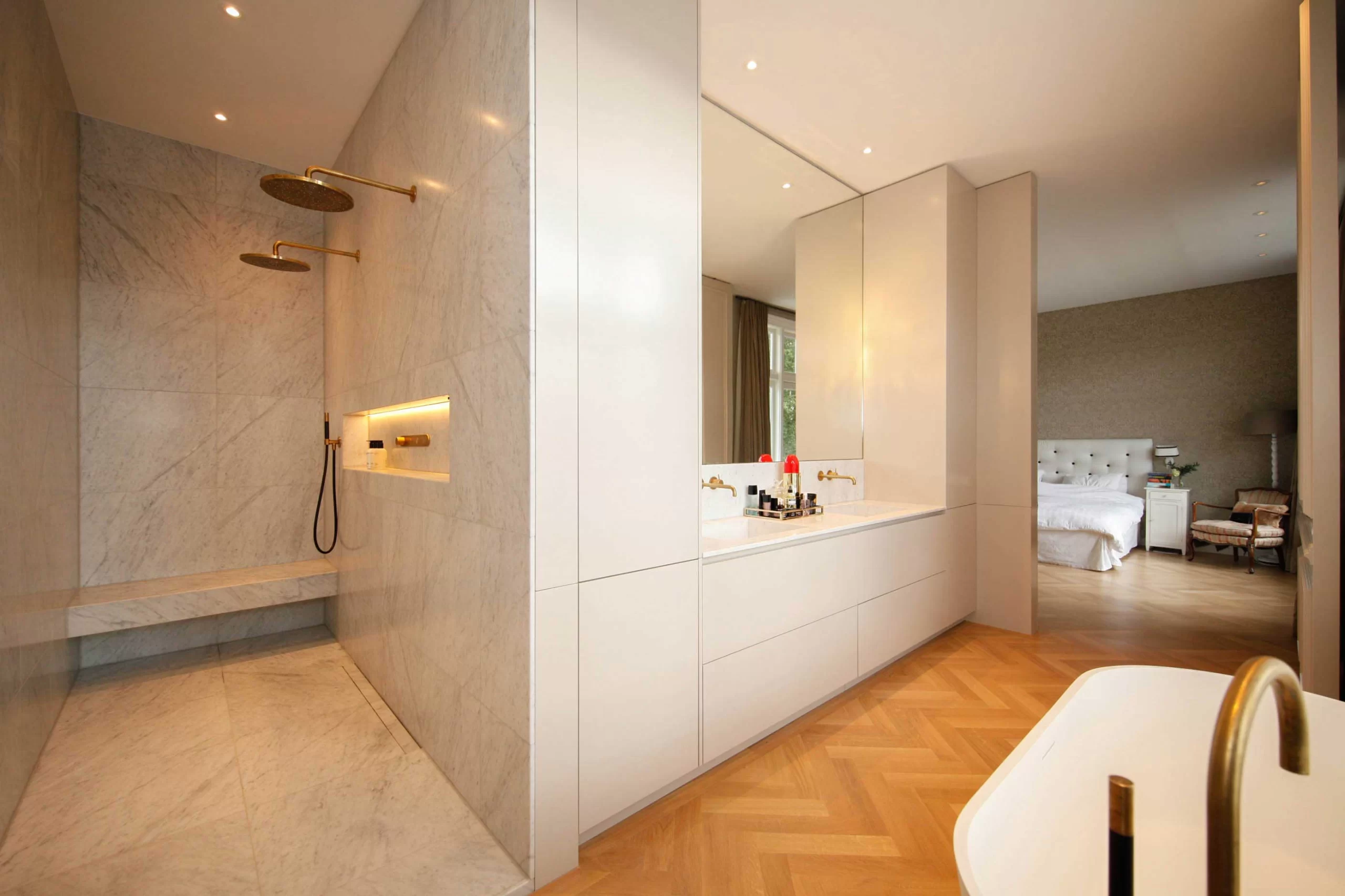 Badkamer met inloopdouche naast een witte kastenwand