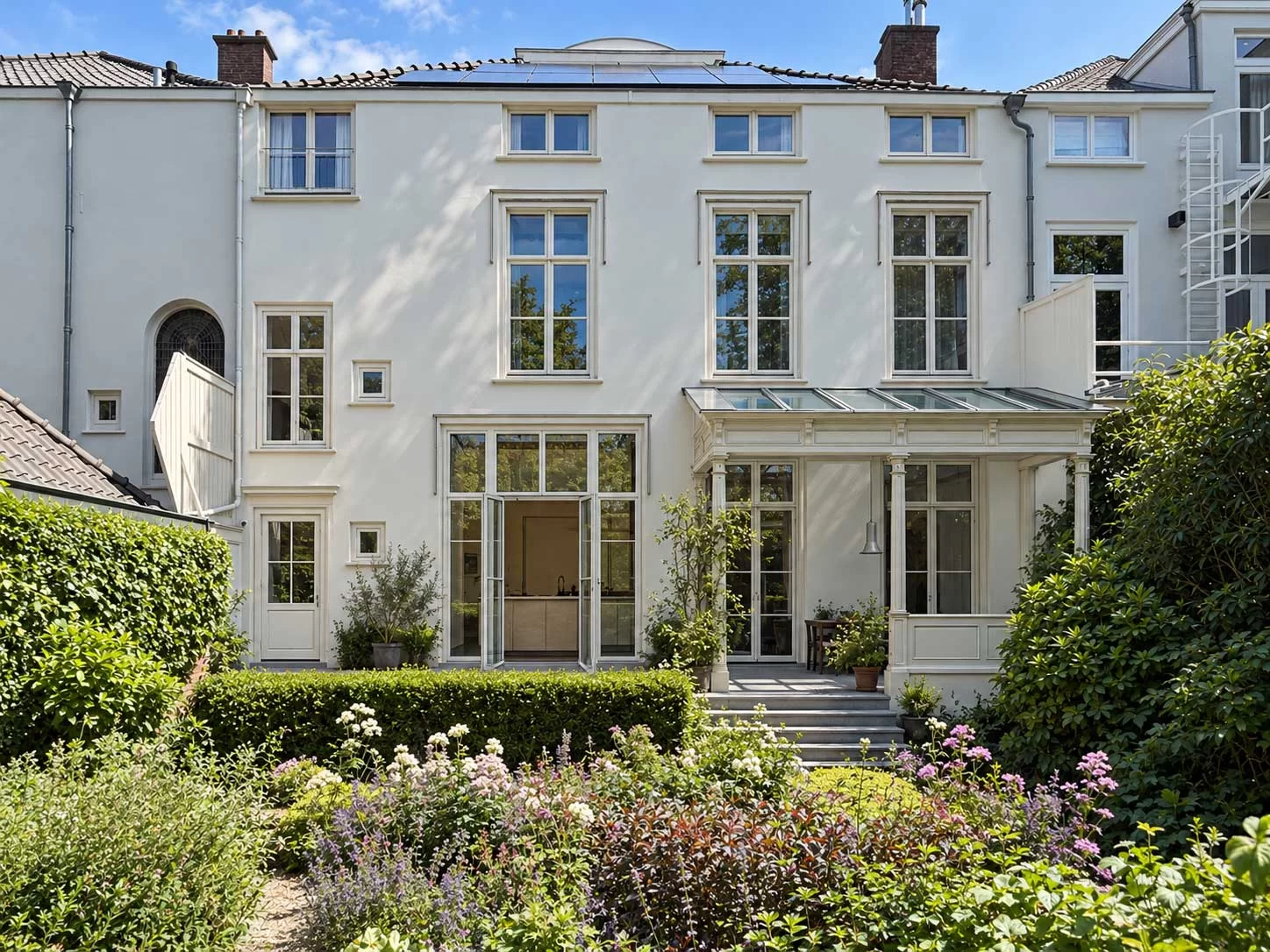 Witte historische gevel aan de tuin bij New tradition